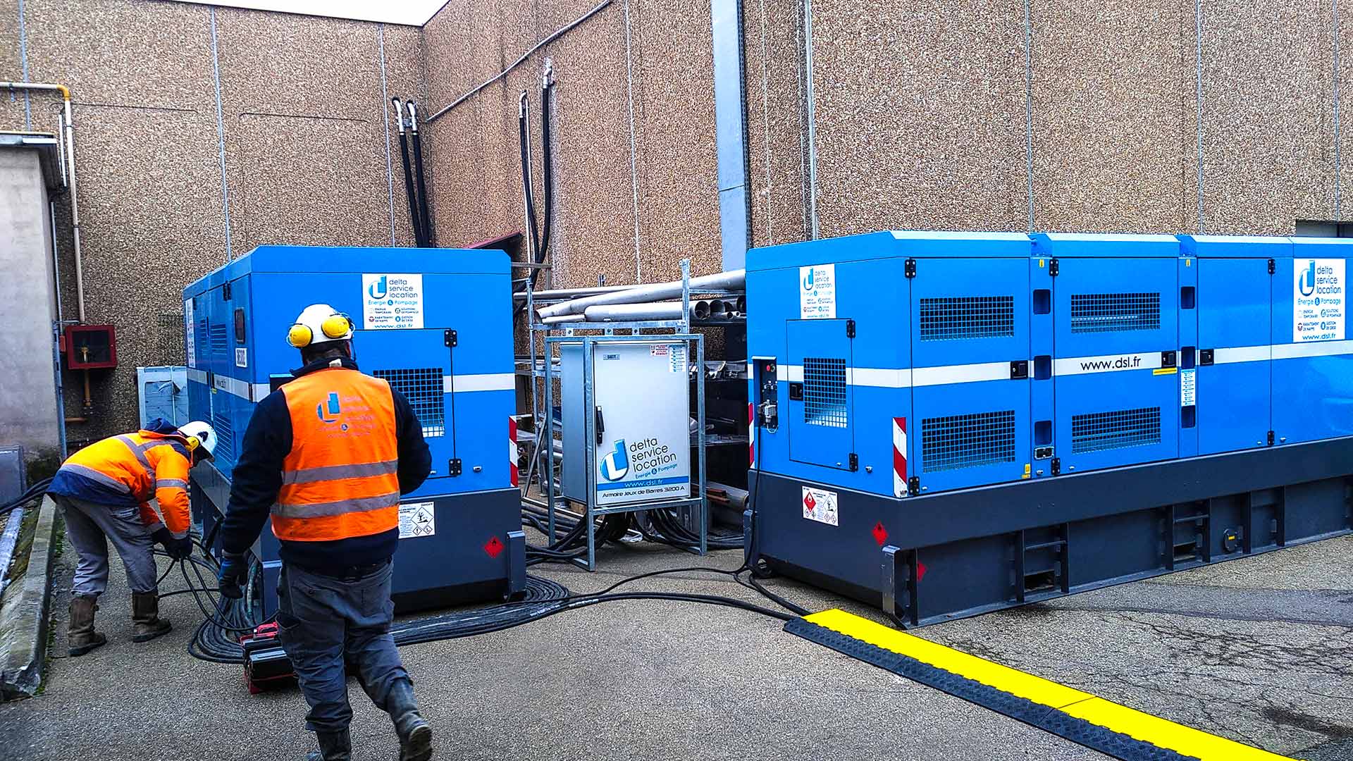 2 techniciens installant 2 groupes électrogènes pour de la gestion de crise