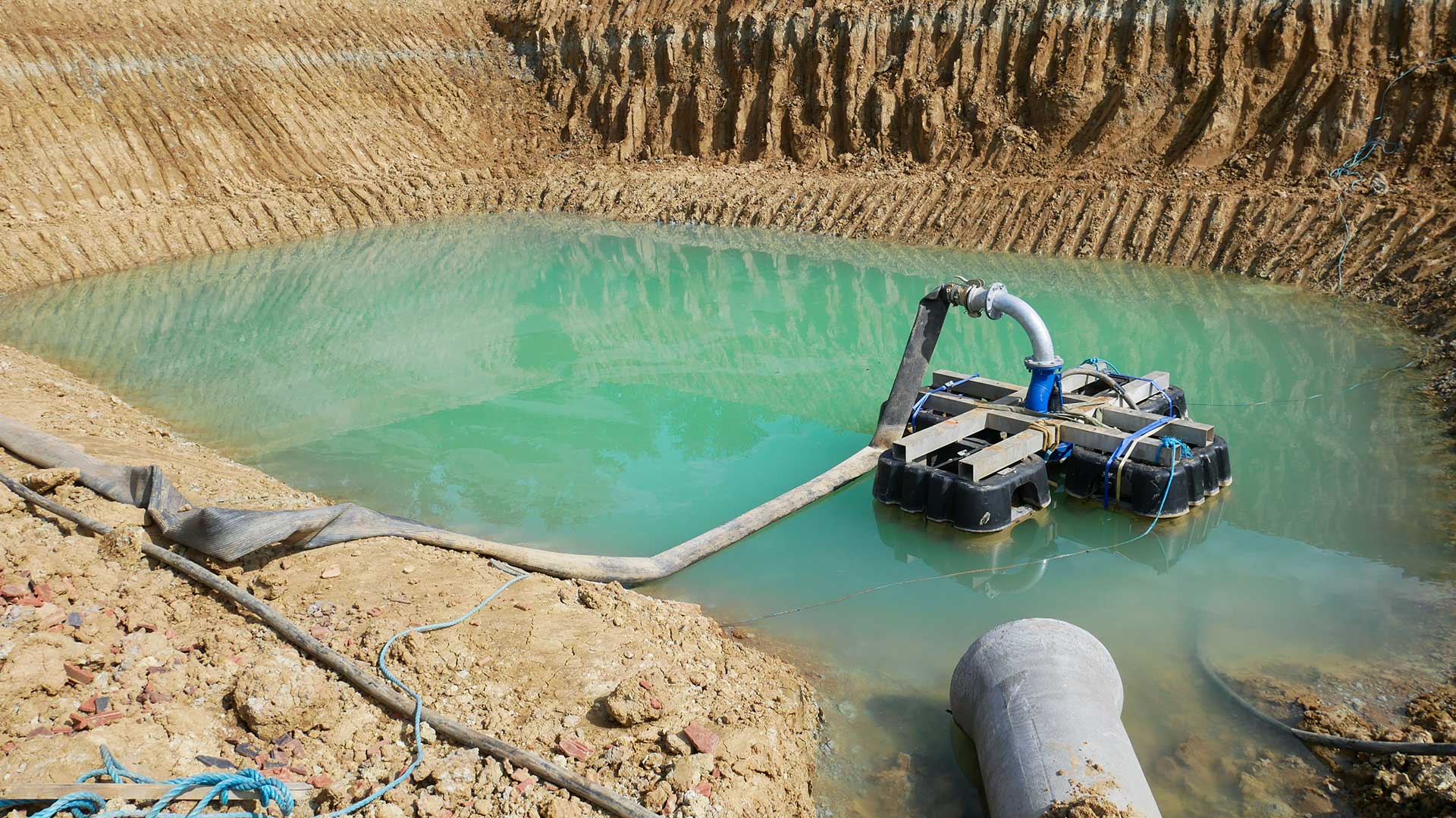 Pompe placée sur un radeau au milieu d'une étendue d'eau au fond de la carrière